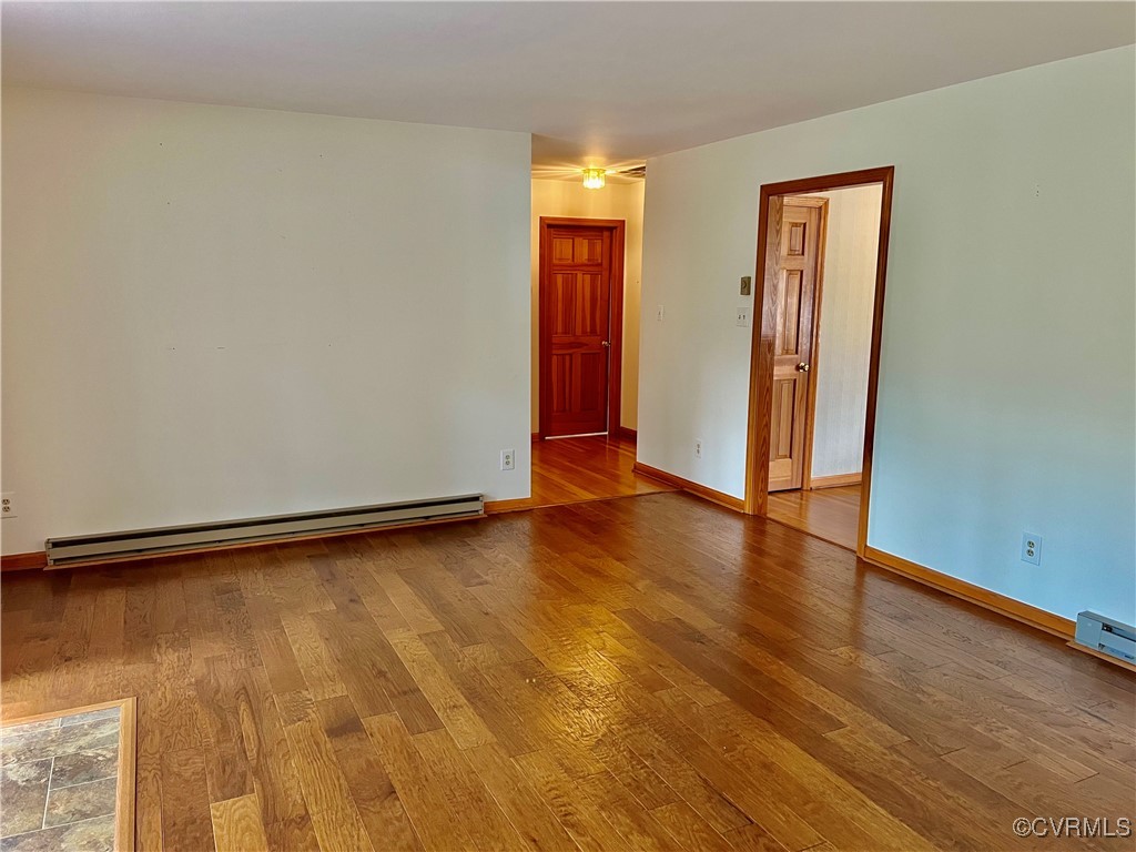 8426 Forge Road Henrico, VA 23228 - Photo 18 of 46 Spare room featuring baseboard heating and wood fi