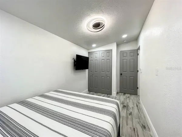 a bedroom with a bed and a flat screen tv