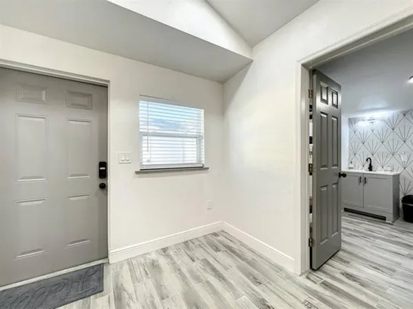 a view of a kitchen from the hallway with a sink and a wooden floor