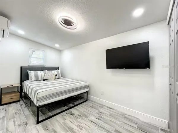 a spacious bedroom with a bed and a flat screen tv