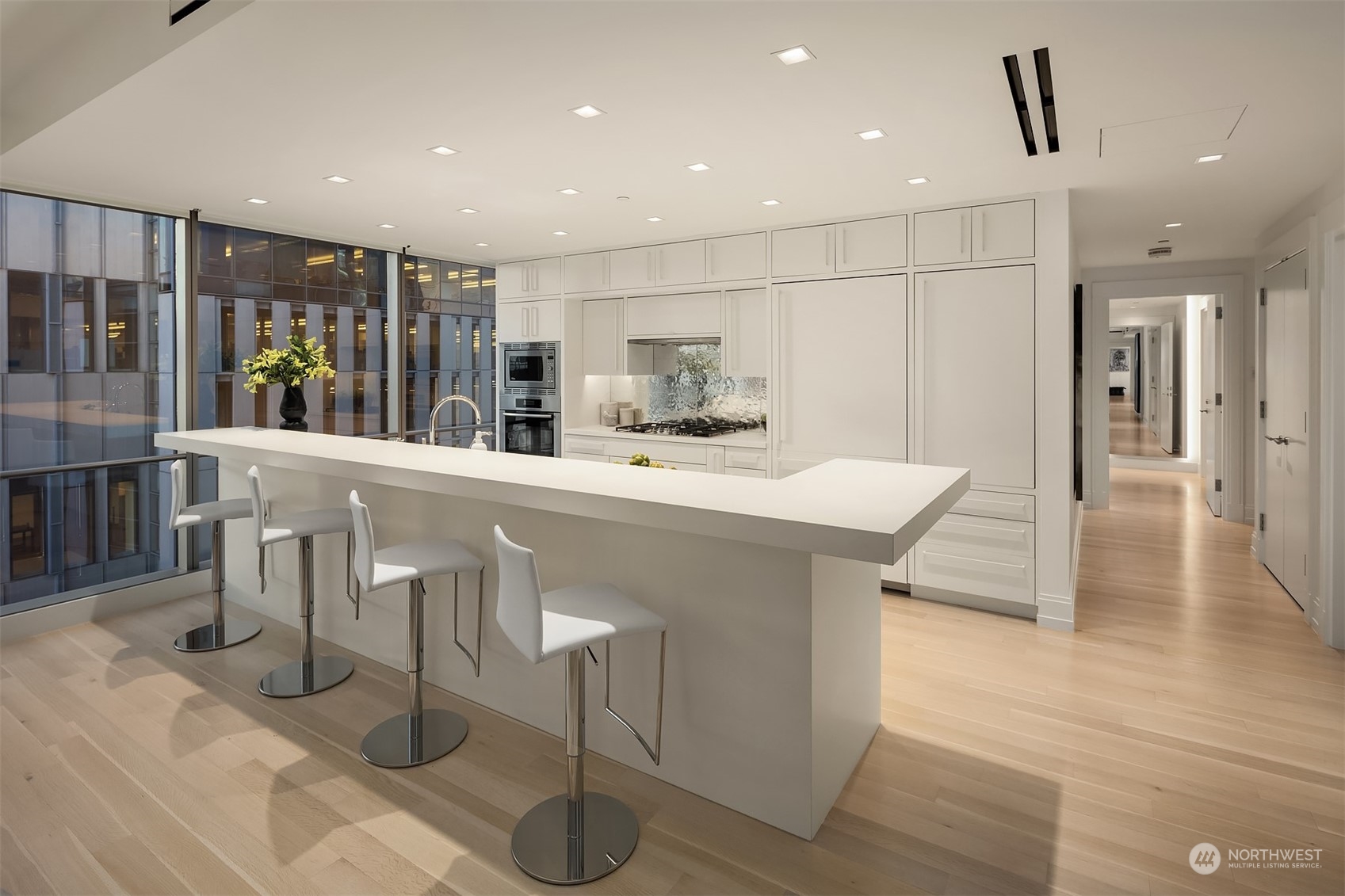 99 Union Street, Unit 1104 Seattle, WA 98101 - Photo 16 of 38 a kitchen with stainless steel appliances kitchen island granite countertop a table chairs and a refrigerator