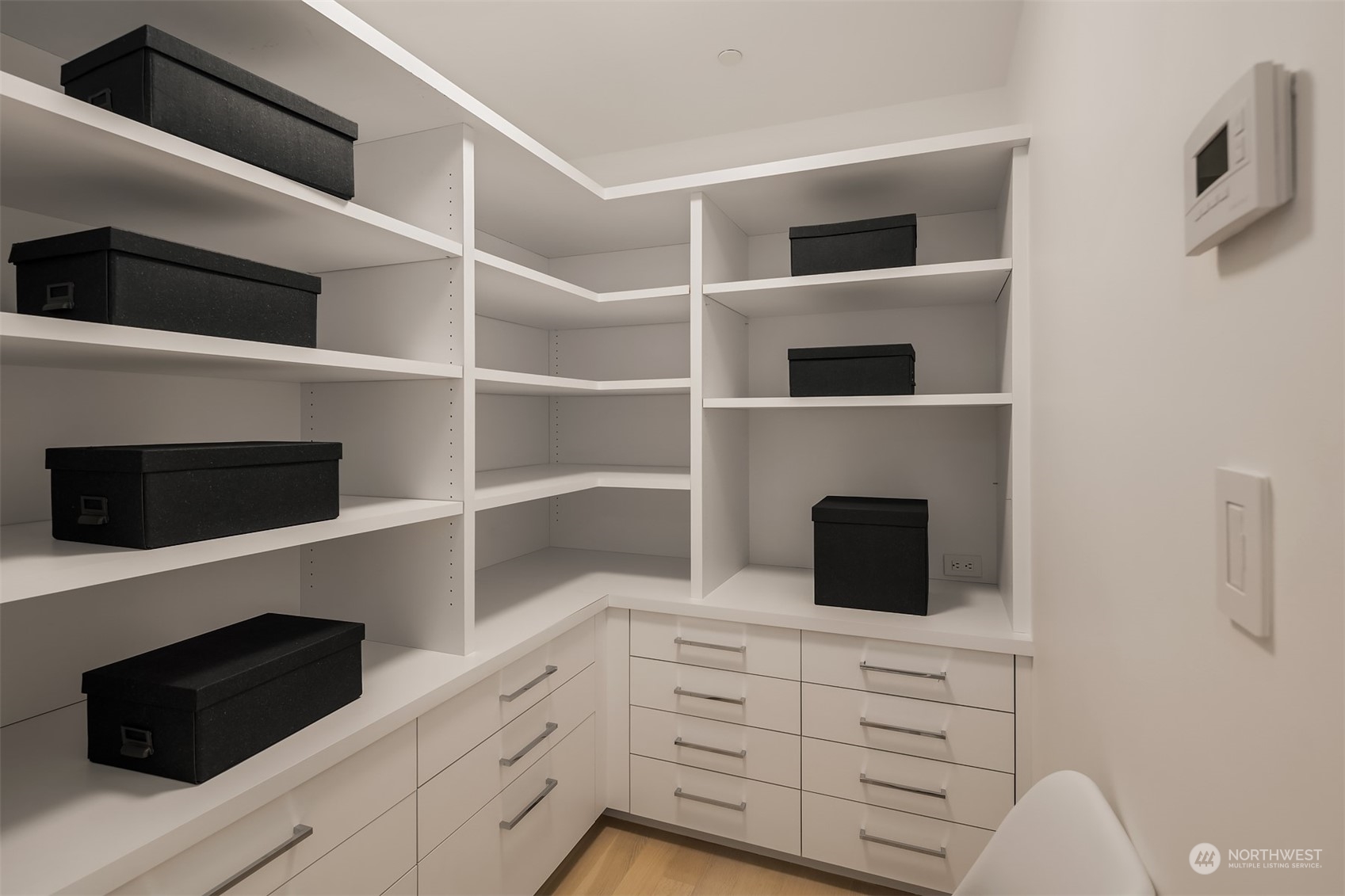 99 Union Street, Unit 1104 Seattle, WA 98101 - Photo 28 of 38 a kitchen with white cabinets and black wooden floor