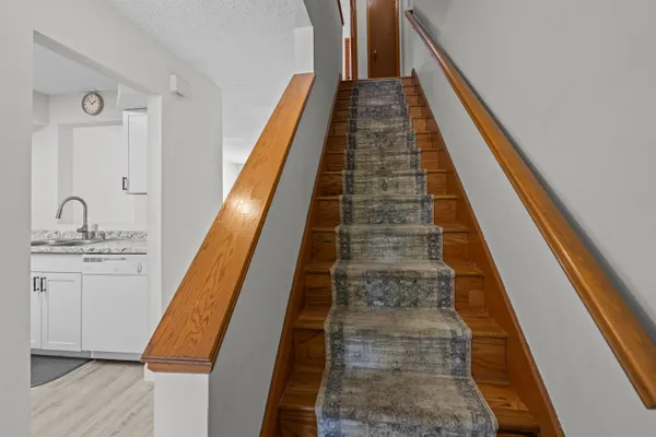 a view of a hallway with wooden floor and staircase