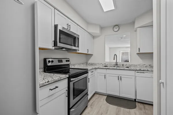 a kitchen with granite countertop a sink and steel appliances
