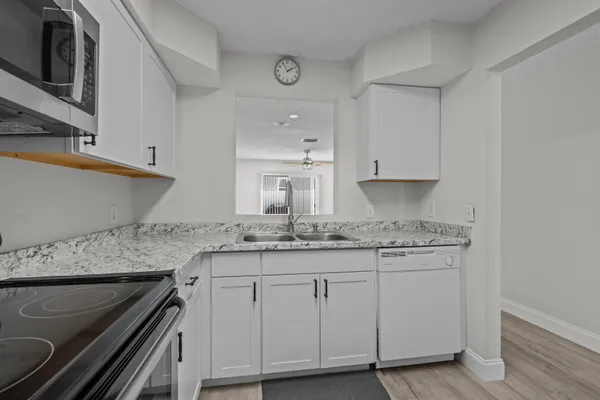 a kitchen with granite countertop a sink stove and cabinets
