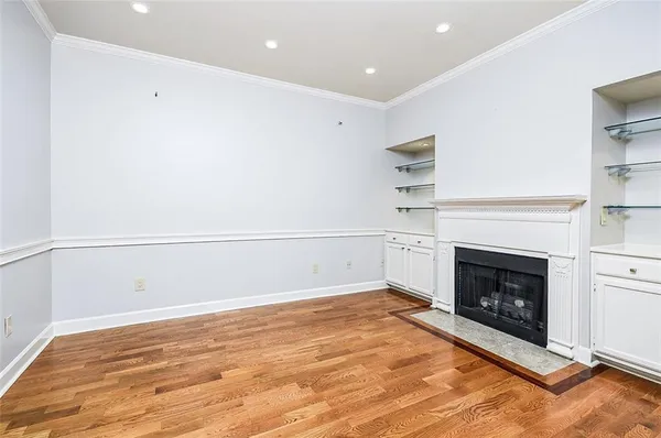 a view of empty room with a fireplace and wooden floor