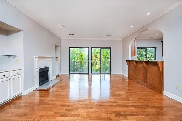 a view of an empty room with a fireplace and a window
