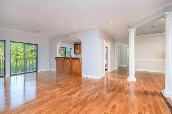a view of a big room with wooden floor and windows