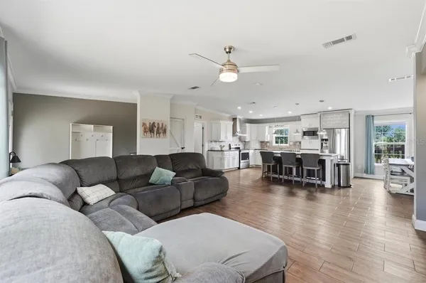 a kitchen with stainless steel appliances granite countertop a sink a stove a refrigerator and white cabinets with wooden floor