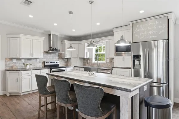 a kitchen with a dining table chairs sink and cabinets