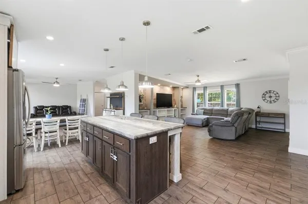 a kitchen with kitchen island a counter top space a sink stainless steel appliances and cabinets