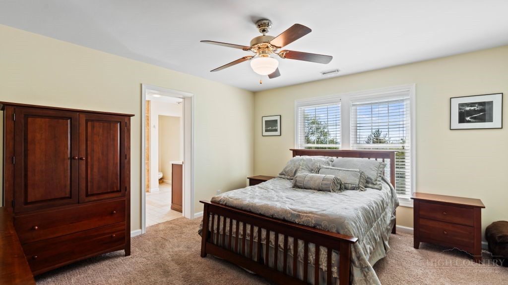 713 Kalmia Lane Boone, NC 28607 - Photo 16 of 50 a bedroom with a large bed and a chandelier