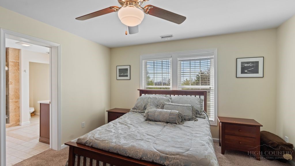 713 Kalmia Lane Boone, NC 28607 - Photo 23 of 50 a bedroom with a bed and a chandelier
