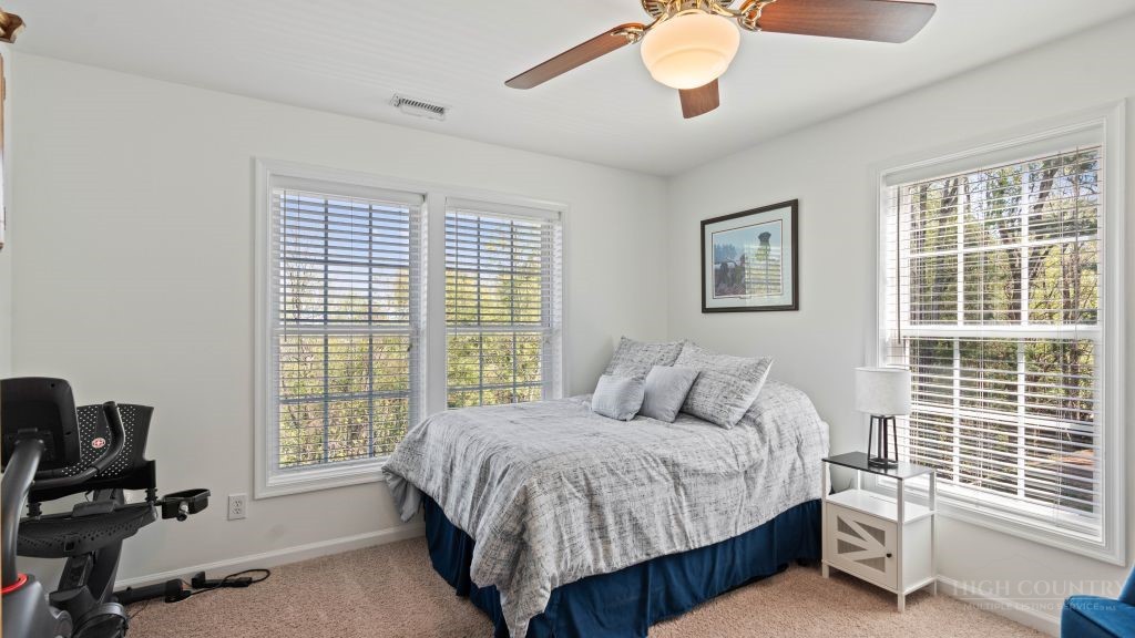 713 Kalmia Lane Boone, NC 28607 - Photo 25 of 50 a bedroom with a large bed and a chandelier
