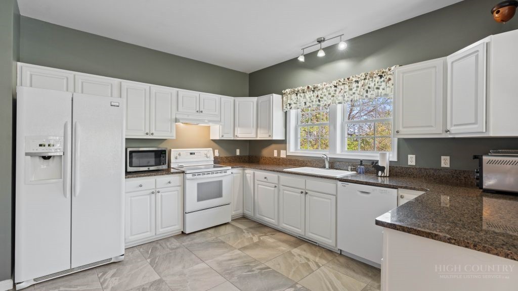 713 Kalmia Lane Boone, NC 28607 - Photo 4 of 50 a kitchen with cabinets appliances a sink and a window