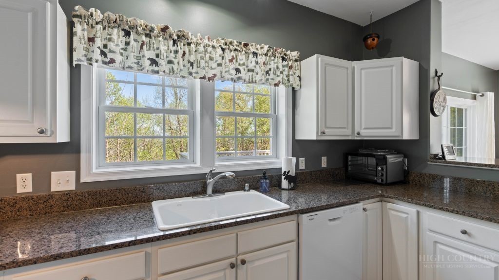 713 Kalmia Lane Boone, NC 28607 - Photo 5 of 50 a kitchen with granite countertop a sink window and cabinets