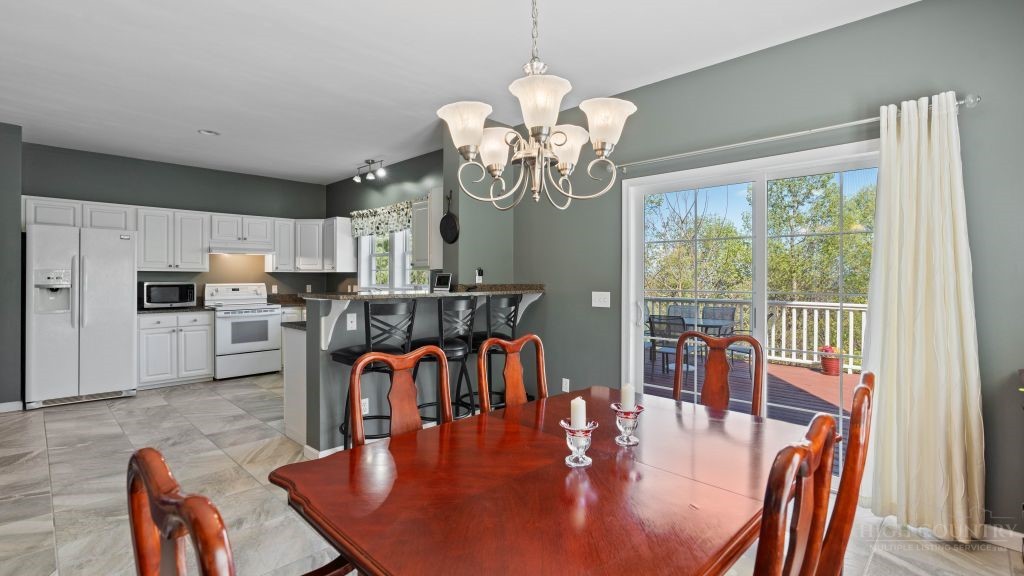 713 Kalmia Lane Boone, NC 28607 - Photo 8 of 50 a dining room with furniture a chandelier and wooden floor
