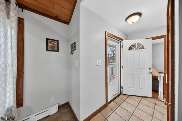 a view of a livingroom with furniture wooden floor fire place and windows