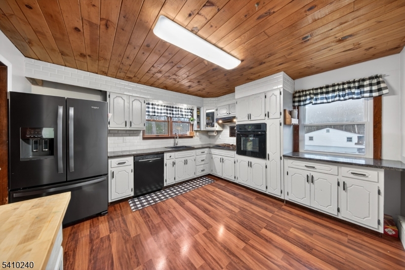 5 Birch Road Andover, NJ 07821 - Photo 29 of 41 a kitchen with stainless steel appliances granite countertop a refrigerator a sink dishwasher a stove and white countertops with wooden floor