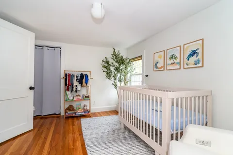 a view of a bedroom with baby crib and furniture