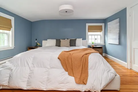 a bed sitting in a bedroom next to a window