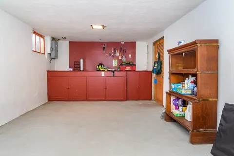 a view of an empty room with bookshelf and a window