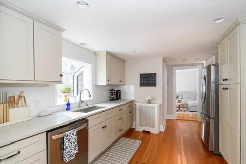 a kitchen with granite countertop a sink stove and cabinets