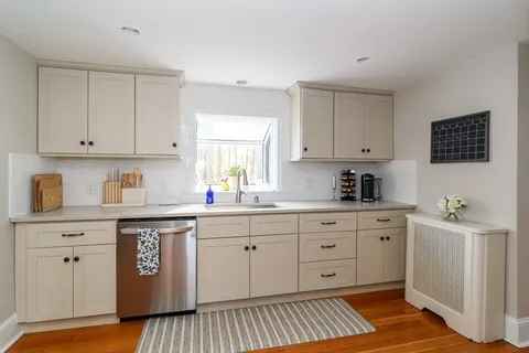 a kitchen with stainless steel appliances granite countertop a sink and cabinets with wooden floor