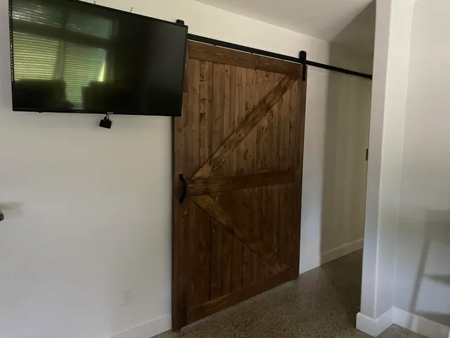 a view of a dining room with furniture one side kitchen view and wooden floor