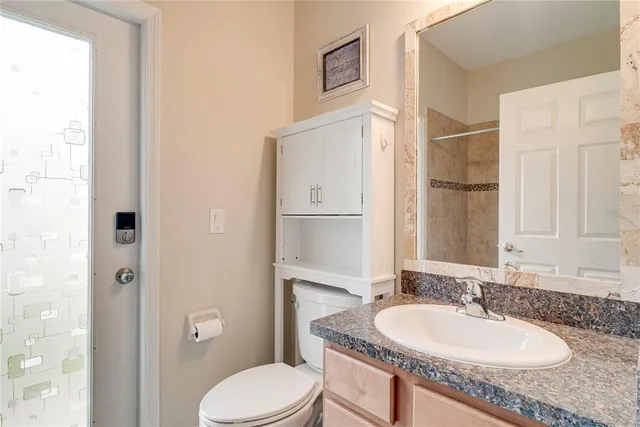 a bathroom with a granite countertop sink toilet and shower