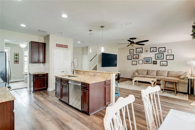 a open kitchen with stainless steel appliances granite countertop a stove and a refrigerator
