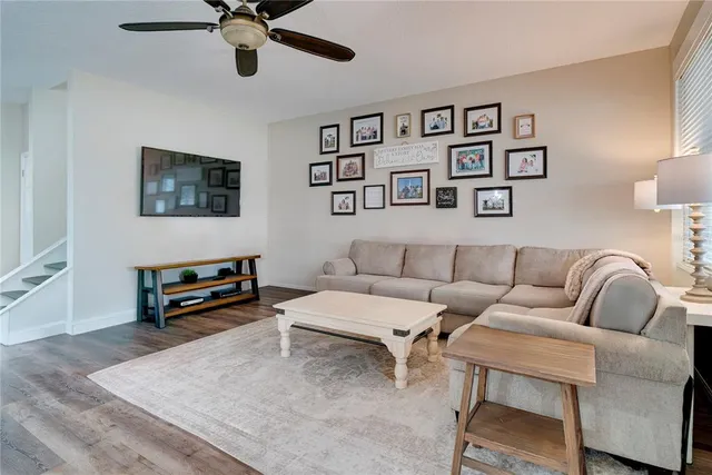 a living room with furniture and a flat screen tv with wooden floor