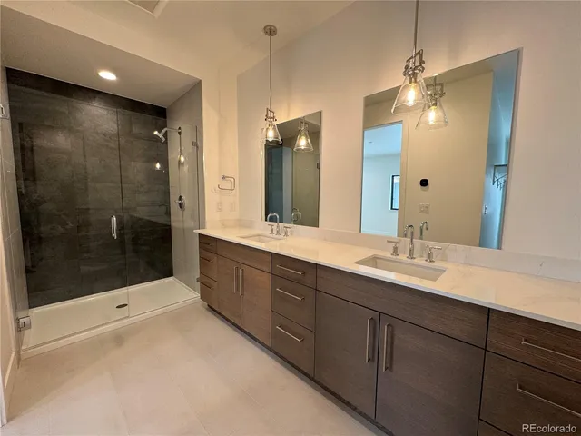 a bathroom with a double vanity sink mirror double and shower