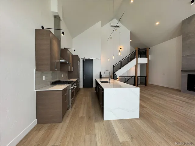 a large room with wooden floor and staircase