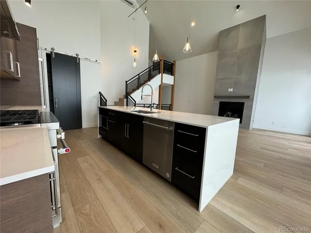 a kitchen with stainless steel appliances a sink cabinets and wooden floor