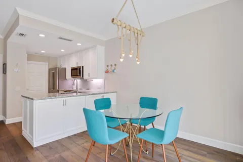a living room with furniture kitchen view and a potted plant