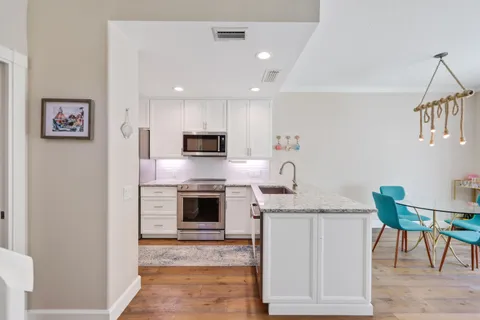 a kitchen with stainless steel appliances granite countertop a stove microwave and sink