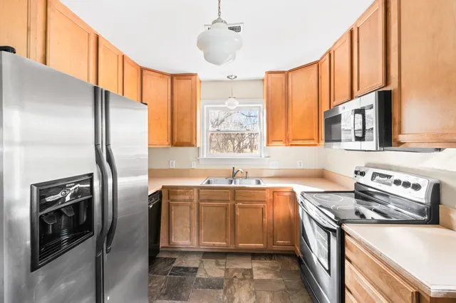 a kitchen with stainless steel appliances granite countertop a sink stove and refrigerator