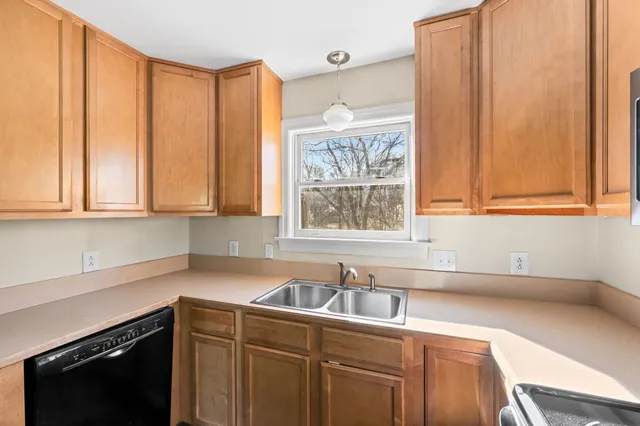 a kitchen with stainless steel appliances a sink a window and cabinets