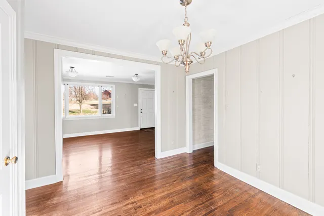 a view of a room with wooden floor and chandelier