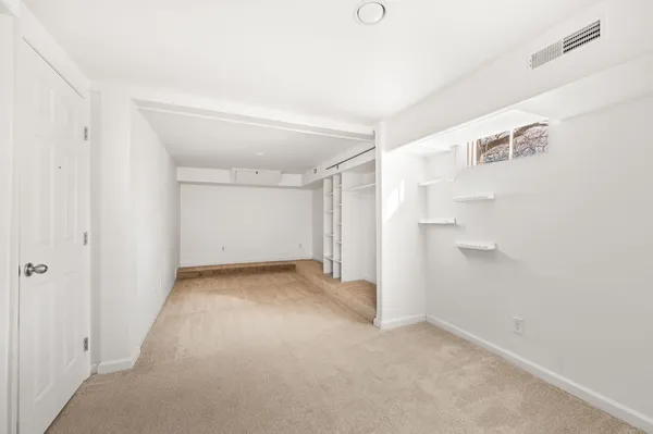 a view of a hallway with a dining table and chairs