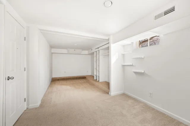 a view of a hallway with a dining table and chairs