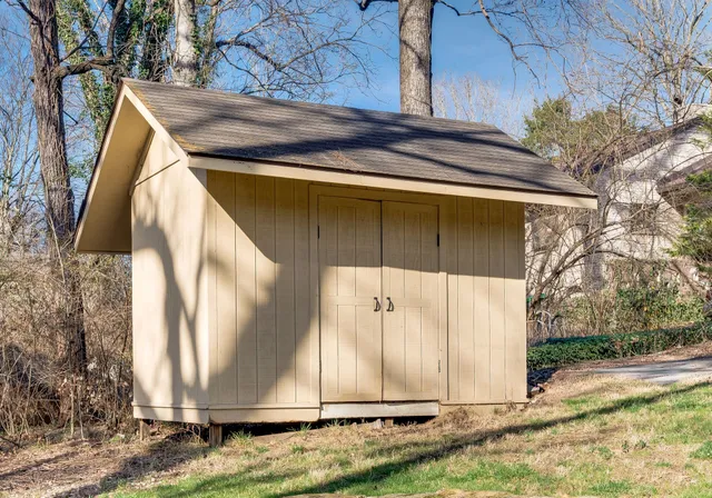 a backyard of a house with a yard and large trees