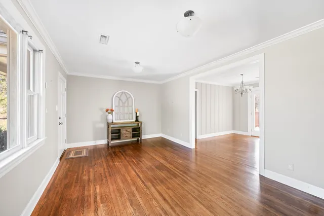 a view of empty room with wooden floor and window