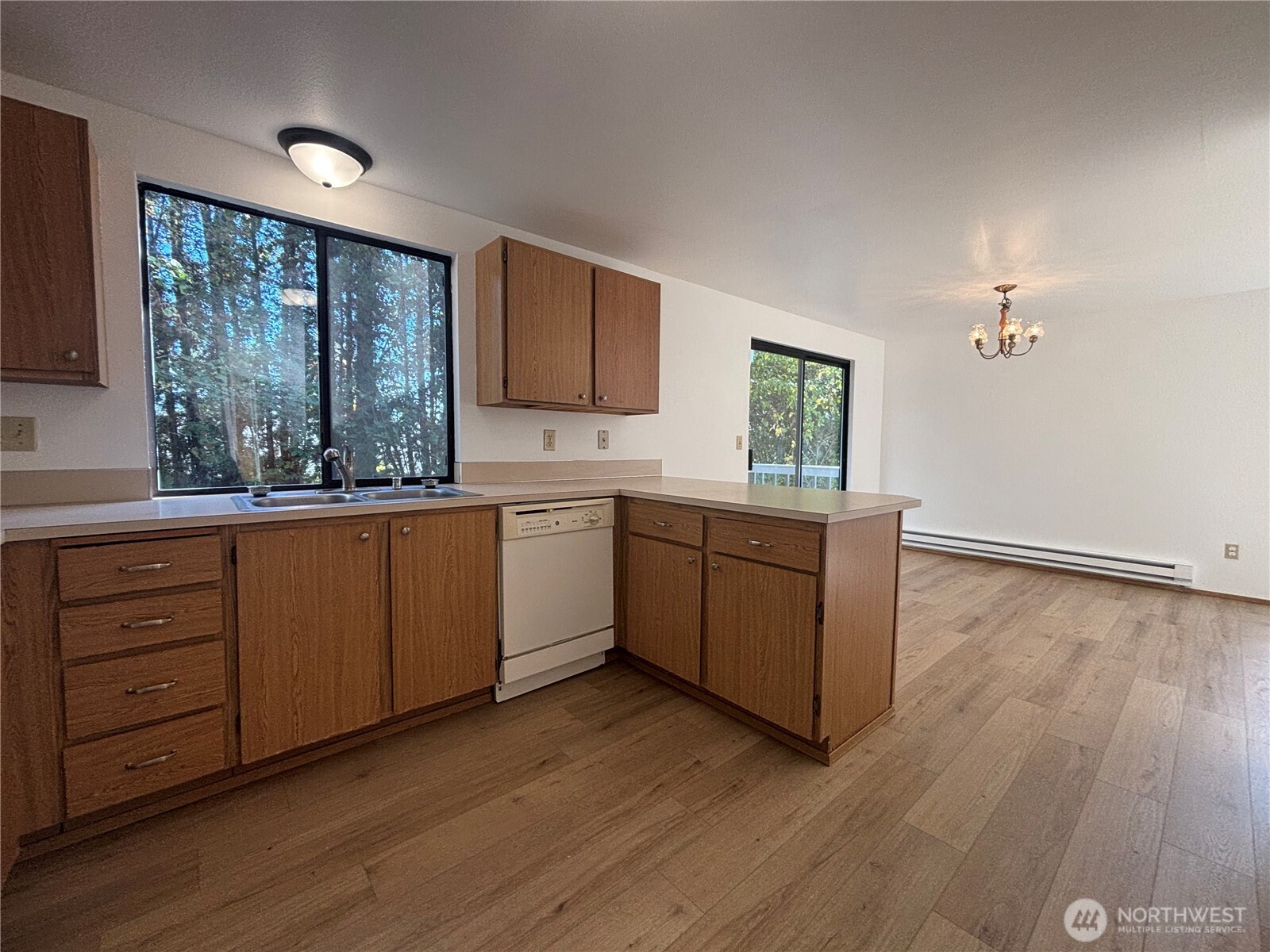 2638 Cascade Trail, Unit A Bremerton, WA 98310 - Photo 8 of 13 a kitchen with wooden floors and white cabinets