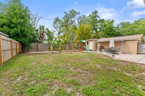 a front view of house with yard and trees in the background