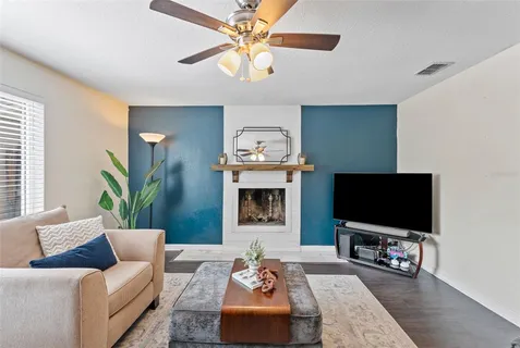 a living room with furniture a flat screen tv and a fireplace