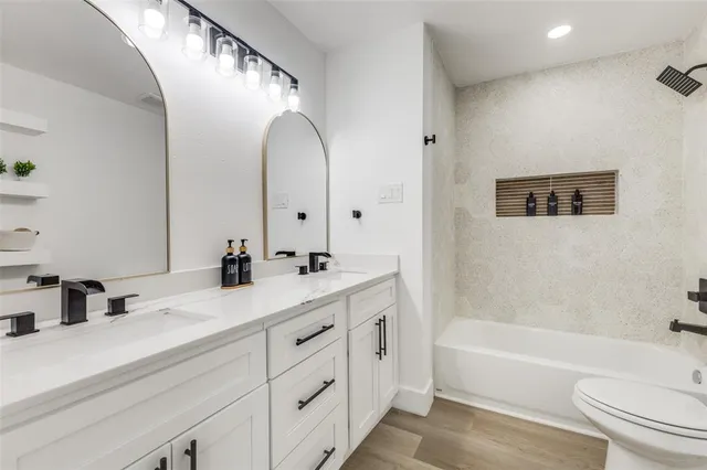 a bathroom with a tub a sink and a large mirror