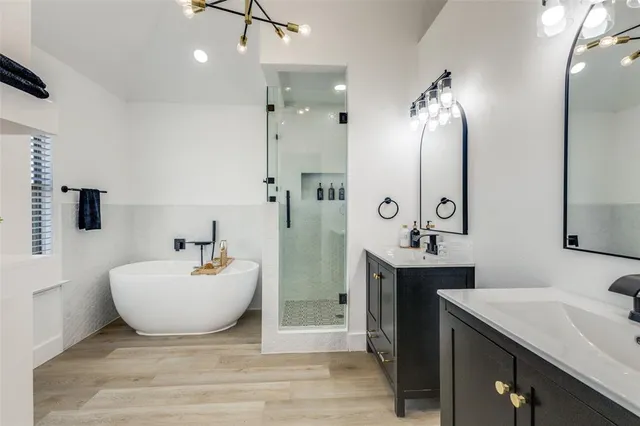a spacious bathroom with a double vanity sink mirror and bathtub