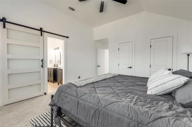 a spacious bedroom with a bed and cabinet